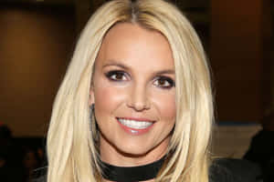 Britney Spears 微笑，金髮和黑色頸鏈。