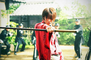 年輕武士身穿紅袍，手持武士刀，在庭院中面對制服軍官。 — 日本武士 壁紙