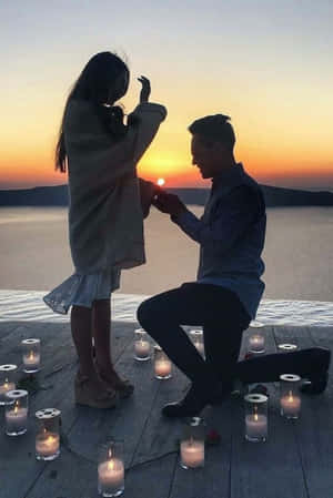 男子在日落時分在碼頭用燭光向女子求婚