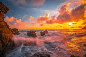 夕陽映照海洋，海浪拍打岩石