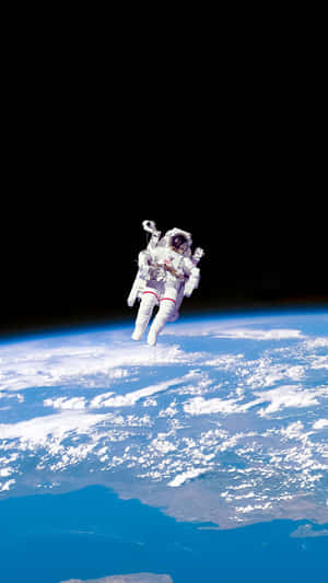 穿著太空衣的太空人漂浮在地球的藍色海洋和白色雲層之上。
