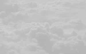 從上方俯瞰蓬鬆雲朵的寧靜景象，呈現柔和的灰色和白色調。