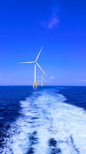 船隻尾流在日落時分接近海上風力發電機。
