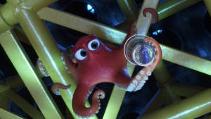 紅色卡通章魚拿著玻璃杯，裡面有紫色小生物，在黃色管道內。