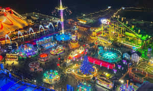 夜間遊樂園，明亮遊樂設施與節慶燈光。