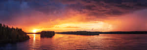 夕陽映照在湖面上，森林覆蓋的島嶼反射出溫暖的色彩。