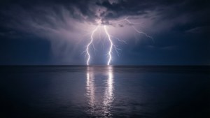 閃電在夜間擊中海洋，在水面上產生明亮的反射。