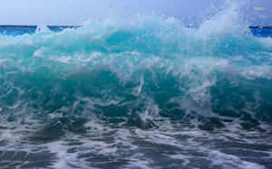 綠松色海浪帶著白色泡沫沖向海岸。