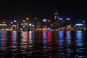 香港天際線夜景，五彩燈光倒映在水面上。