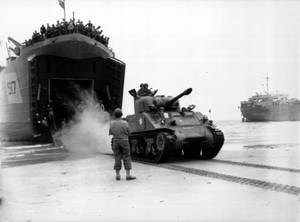 士兵和一輛坦克在軍事行動中從登陸艦下到沙灘。