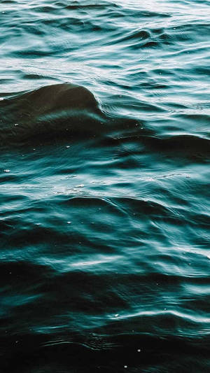 深藍綠色海浪，在氣氛燈光下帶有柔和漣漪和暗影。