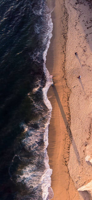 兩人在沙灘上放鬆，海浪湧入。