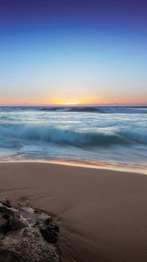 夕陽映照海洋，海浪拍打沙灘 — 手機壞咗 GIF 壁紙