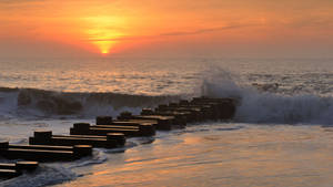 海洋上的夕陽，海浪拍打防波堤塊