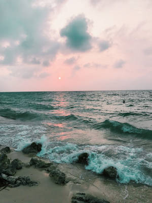 夕陽映照海洋，海浪在黃昏時拍打岩石海灘 — 沙灘 壁紙