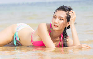 身穿彩色比基尼的女性在陽光明媚的海灘海水中放鬆