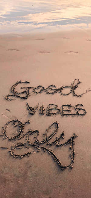Good Vibes Only 用貝殼寫在日落時濕潤的沙灘上