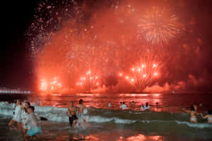 海洋中的人群在夜間觀看紅色煙火 — 煙火 壁紙