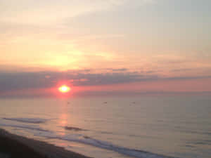 日落海景，船隻和輕柔的海浪