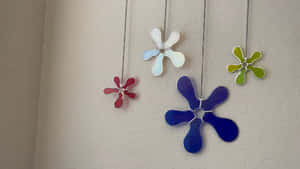 四個懸掛的花窗玻璃花朵裝飾品，顏色有紅、藍、綠和白。