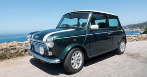 經典的綠色Mini Cooper，白色車頂，在陽光明媚的日子停在海邊。 — 海洋 壁紙
