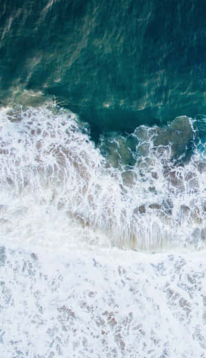 海浪拍打岩石並產生白色泡沫的空中拍攝。