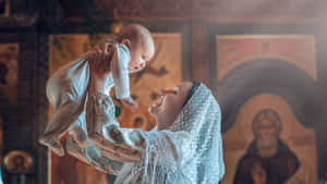 母親在教堂裡舉起嬰兒，身後有宗教圖標