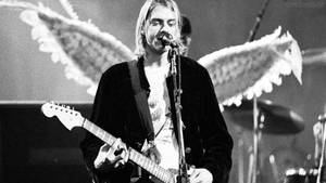 Kurt Cobain 在現場演唱會中帶著天使翅膀彈結他。