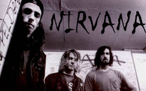 三名垃圾搖滾風格男子在帶有「NIRVANA」文字的塗鴉牆前擺姿勢。