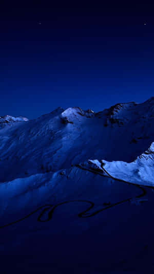 積雪的山口，在星空下有一條蜿蜒的道路 — 簡約藍色美學 壁紙