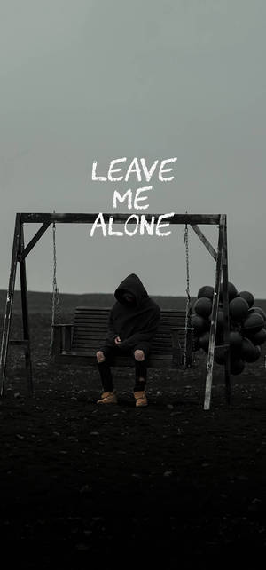 穿連帽衫的人坐在鞦韆長椅上，帶有 leave me alone 文字