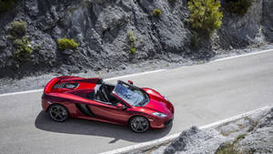 紅色McLaren開篷車在懸崖旁的山路上飛馳。