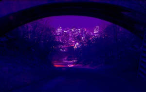 夜晚透過石拱門看到的紫色城市燈光