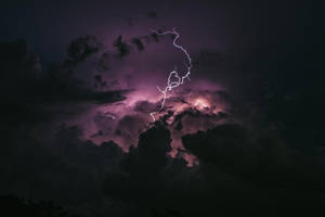 閃電劃過黑暗的暴風雨天空，伴隨著紫色的雲層。