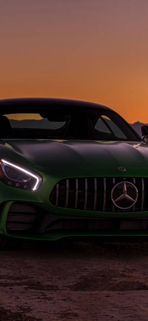 日落時分，綠色Mercedes-AMG GT跑車車燈閃爍。