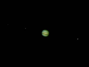 黑暗太空中的綠色行星帶有條紋，遠處有星星