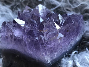 一組被白煙籠罩的紫色紫水晶晶體簇。 — 暗色 壁紙
