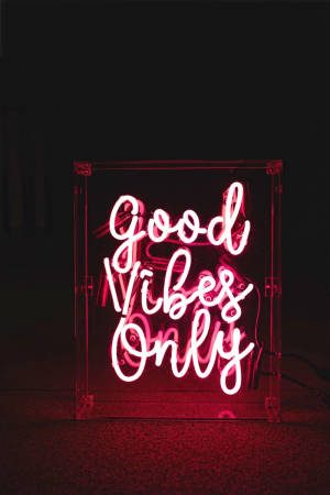 粉紅色霓虹燈牌，在黑暗房間中以草書文字顯示 Good Vibes Only。 — 窩心語錄 壁紙