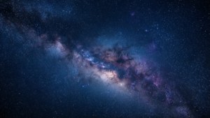 深邃太空中，一個令人驚嘆的深藍色星系，點綴著繁星與星雲。