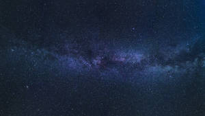 銀河系在漆黑的夜空中閃爍著紫色和藍色的星星。 — 太空 壁紙