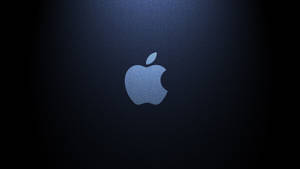 Apple標誌在深藍色紋理背景上被照亮。