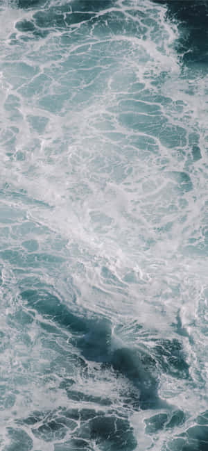 深藍綠色海水中翻騰的海洋波浪與旋轉的白色泡沫。 — OnePlus 壁紙