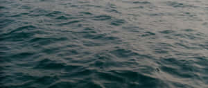柔和暮光下的深藍綠色海浪。 — 2560x1080 壁紙