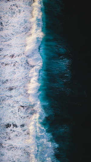 從高空拍攝海洋波浪在深藍色海水中破碎成白色泡沫。