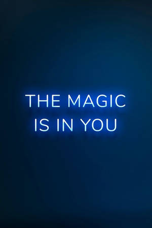 藍色霓虹燈牌，在深色背景上顯示文字「THE MAGIC IS IN YOU」。
