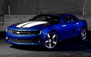 帶有白色條紋的藍色雪佛蘭 Camaro SS 在夜間停靠在磚牆附近。 — 汽車 壁紙