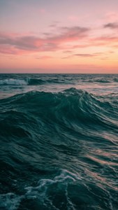 海浪在粉紅與橙色的日落天空下翻滾。