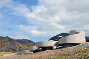 岩石山坡上具有曲線建築風格的現代混凝土建築。 — 建築 壁紙