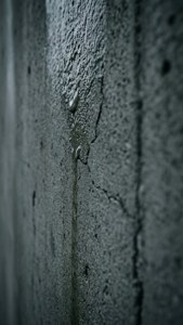 水滴落在裂開的混凝土牆表面。 — 灰色美學 GIF 壁紙
