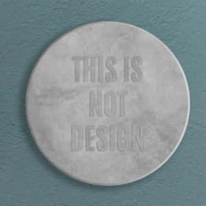 圓形混凝土牌，浮雕文字 'THIS IS NOT DESIGN'，在青綠色牆上。 — 混凝土 壁紙